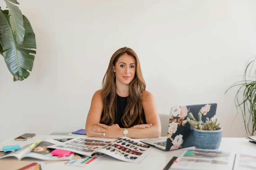 A woman planning at a desk spread with notes and colour samples