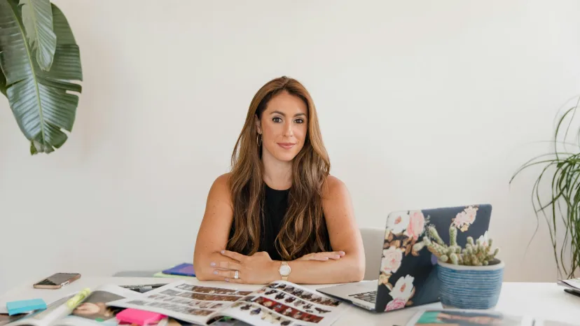 A woman planning at a desk spread with notes and colour samples
