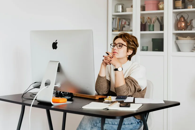 A person working at a desktop computer in a home office