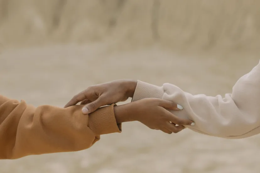 Two people reaching out to hold hands