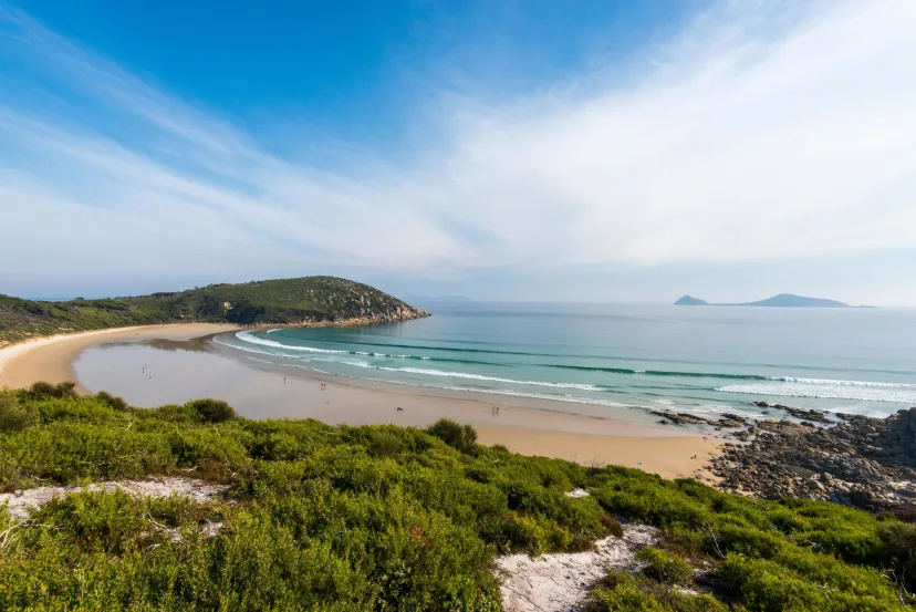 A wide sandy beach and headland on the coast