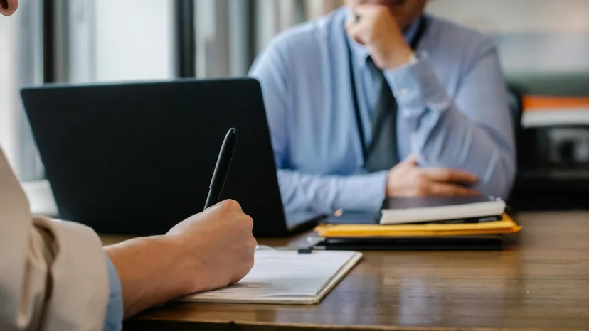 A man making notes at a desk during an assessment