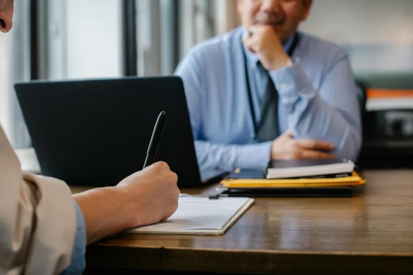 A man making notes at a desk during an assessment